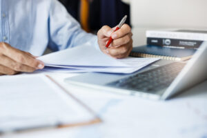 Businessman holding pen checking report