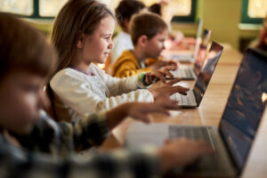 Group of young students using computer on a class at school.